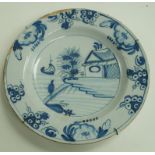 A late 18th century Dutch Delft charger, painted in blue with a boat in a river landscape, 35.