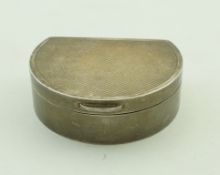 A silver pill box, London 1979, of almost lunette shape, engine turned decoration, 5cm long,