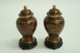 A pair of cloisonné vases of baluster form with domed covers on pierced hardwood stands decorated