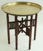 An Indian brass tray on folding Liberty's style stand with bobbin turned panels, 59cm high, 56.