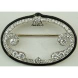 A diamond and black enamel oval Cloche brooch, signed 'Cartier N.Y.' and indistinctly numbered, 4.