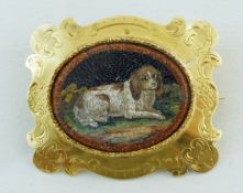 A 19th century micro mosaic brooch, the central oval panel depicting a recumbent spaniel,
