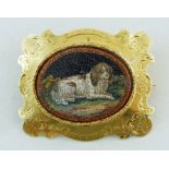 A 19th century micro mosaic brooch, the central oval panel depicting a recumbent spaniel,