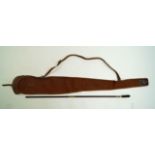 A vintage brown canvas gun slip and a wooden and brass two piece gun cleaning rod