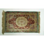 A silk rug with central medallion on a flower filled red ground, within two borders, signed,  92.