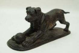 A bronze figure of a dog crouched before a ball on a rectangular rounded end base, 11cm high, 25.