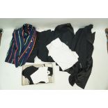 A small collection of vintage clothing, including a striped school blazer, a black tailcoat,