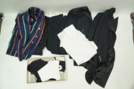 A small collection of vintage clothing, including a striped school blazer, a black tailcoat,