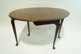 A Georgian style mahogany oval drop leaf table standing on turned legs and pad feet, 110cm high,