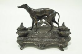 A bronze inkwell desk stand surmounted by a figure of a greyhound,
