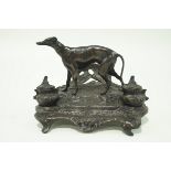 A bronze inkwell desk stand surmounted by a figure of a greyhound,