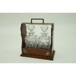 A mahogany tantalus with silver plated mounts,