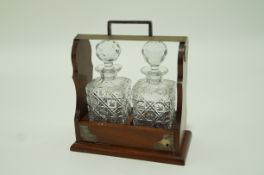 A mahogany tantalus with silver plated mounts,