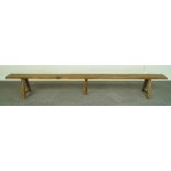 A long French fruitwood bench with trestle ends and central support, 300cm long,