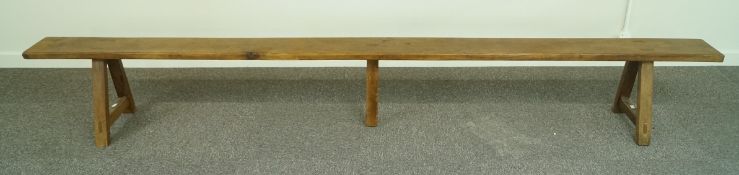 A long French fruitwood bench with trestle ends and central support, 300cm long,