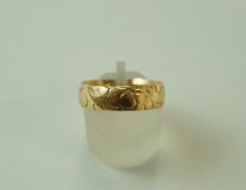 An 18 carat gold wedding ring, was patterned, of very shallow D section, 5.