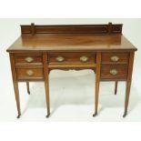 An Edwardian mahogany writing desk with raised back,
