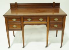 An Edwardian mahogany writing desk with raised back,