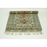 A tribal rug with three cantered medallions on a cream field with two borders,