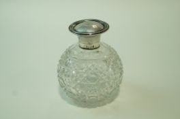 A silver topped scent bottle, the globular hob nail cut body with a hinged cover,