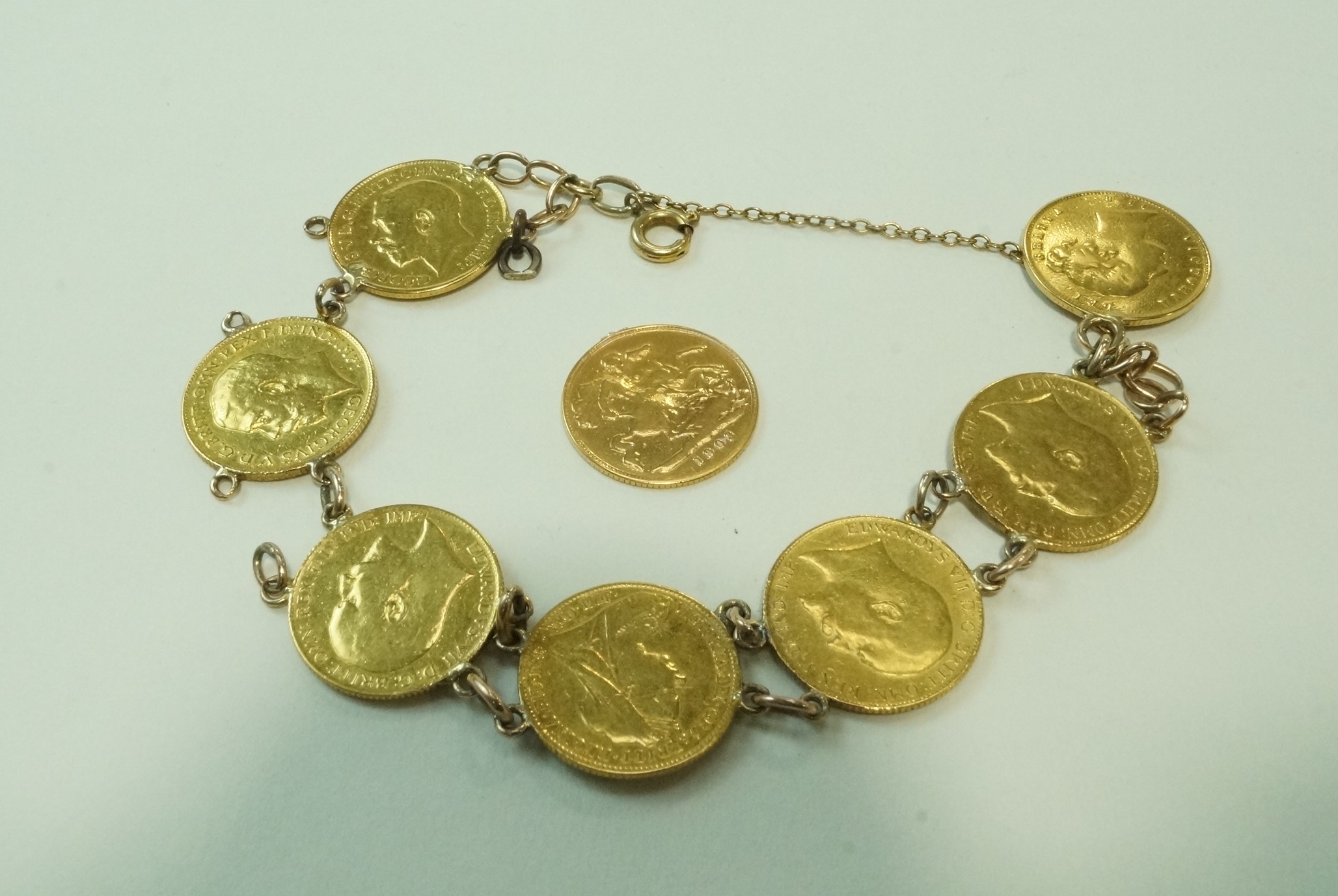 Eight Victorian and Edwardian gold half sovereigns, fashioned into a bracelet,