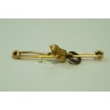 A 15ct gold kitten bar brooch, the young cat playing with a pearl (untested and unwarranted) 'ball',