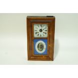 An American wall clock in mahogany case by the Ansonia clock company,