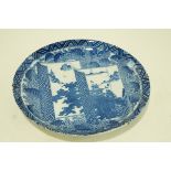 A Japanese porcelain charger printed in blue with landscapes on a leaf and flower ground,