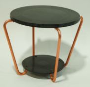 A two tier bakelite table with round disks, linked by four metal supports,
