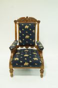A Victorian armchair with carved oak frame, upholstered back, arms and seat,