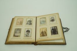 A Victorian embossed leather photograph album opening to reveal a cylinder musical box,