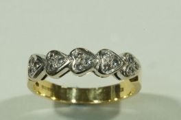 An 18 carat gold diamond set ring, a trio of brilliant cuts to each of the five heart motifs,