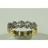 An 18 carat gold diamond set ring, a trio of brilliant cuts to each of the five heart motifs,