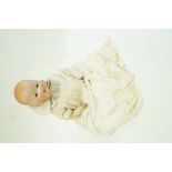 An Annand Marseille baby doll, the bisque head with closing eyes and open mouth,