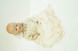 An Annand Marseille baby doll, the bisque head with closing eyes and open mouth,