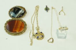 A silver gilt pendant on a chain; a silver gilt ring; a silver gilt wishbone pendant;