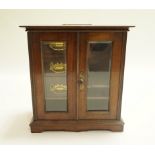An early 20th century mahogany smoker's cabinet with three fitted drawers and pipe hanging rack.
