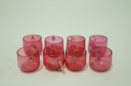 A set of eight cranberry tinted glass custard cups each with clear glass looped handles