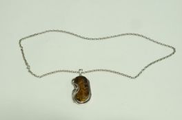 A silver amber set pendant on a chain