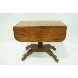 A William IV mahogany Pembroke table with turned pedestal on shaped rectangular base with splayed