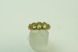 A 9 carat gold three stone peridot ring, in the Victorian style, finger size P, 4.