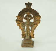 An Indian brass figure of a deity standing on a plinth with pierced back, 10.