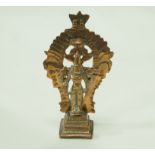 An Indian brass figure of a deity standing on a plinth with pierced back, 10.