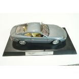 A die cast model of an Aston Martin DB7 on black plinth base