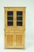 A continental pine side cabinet with two glazed doors,