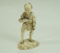 A late 19th century Japanese carved ivory figure, holding a parcel on a mound base, 10.