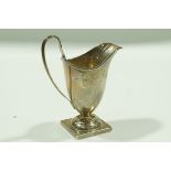 A silver cream jug, Chester 1937, of helmet shape in the Georgian style, to a square foot,