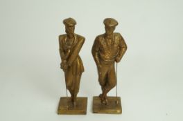 A pair of mid 20th century gilt painted model of a male and female golfer,