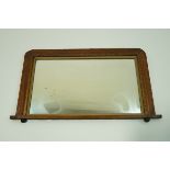 A 20th century mahogany mantel mirror, with inlaid decoration on bun feet,