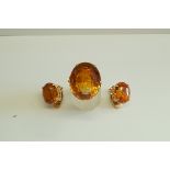 A large citrine single stone ring; with a pair of matching ear clips;